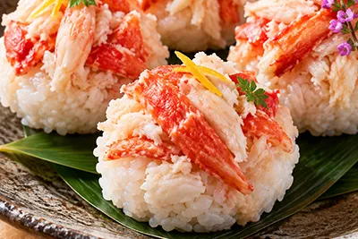 たらば蟹の荒ほぐし身をのせた手毬寿司の調理例