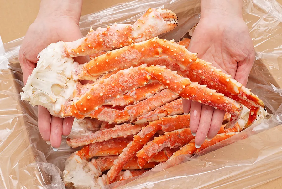北海道産タラバガニ訳ありカニ足2kg箱。箱に入った冷凍状態のカニ足の実物写真