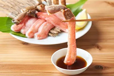 本ズワイガニのかにしゃぶをたれにつけて味わう様子