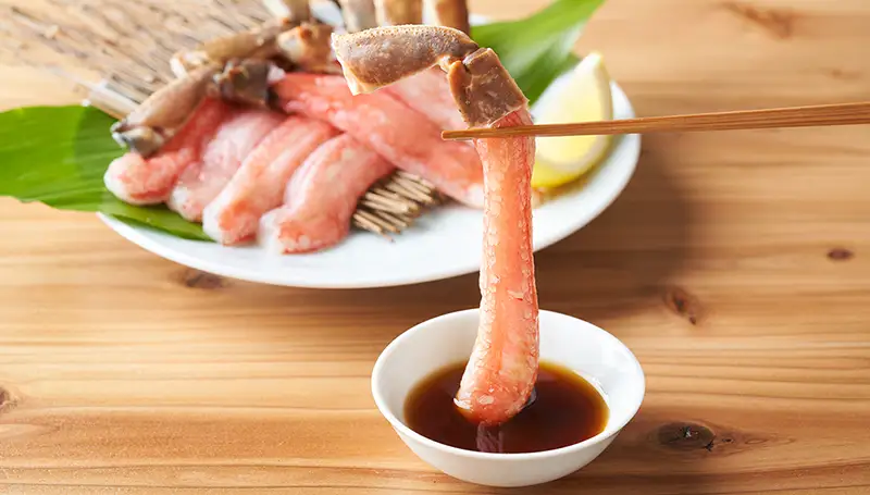 本ズワイガニのかにしゃぶをたれにつけて味わう様子